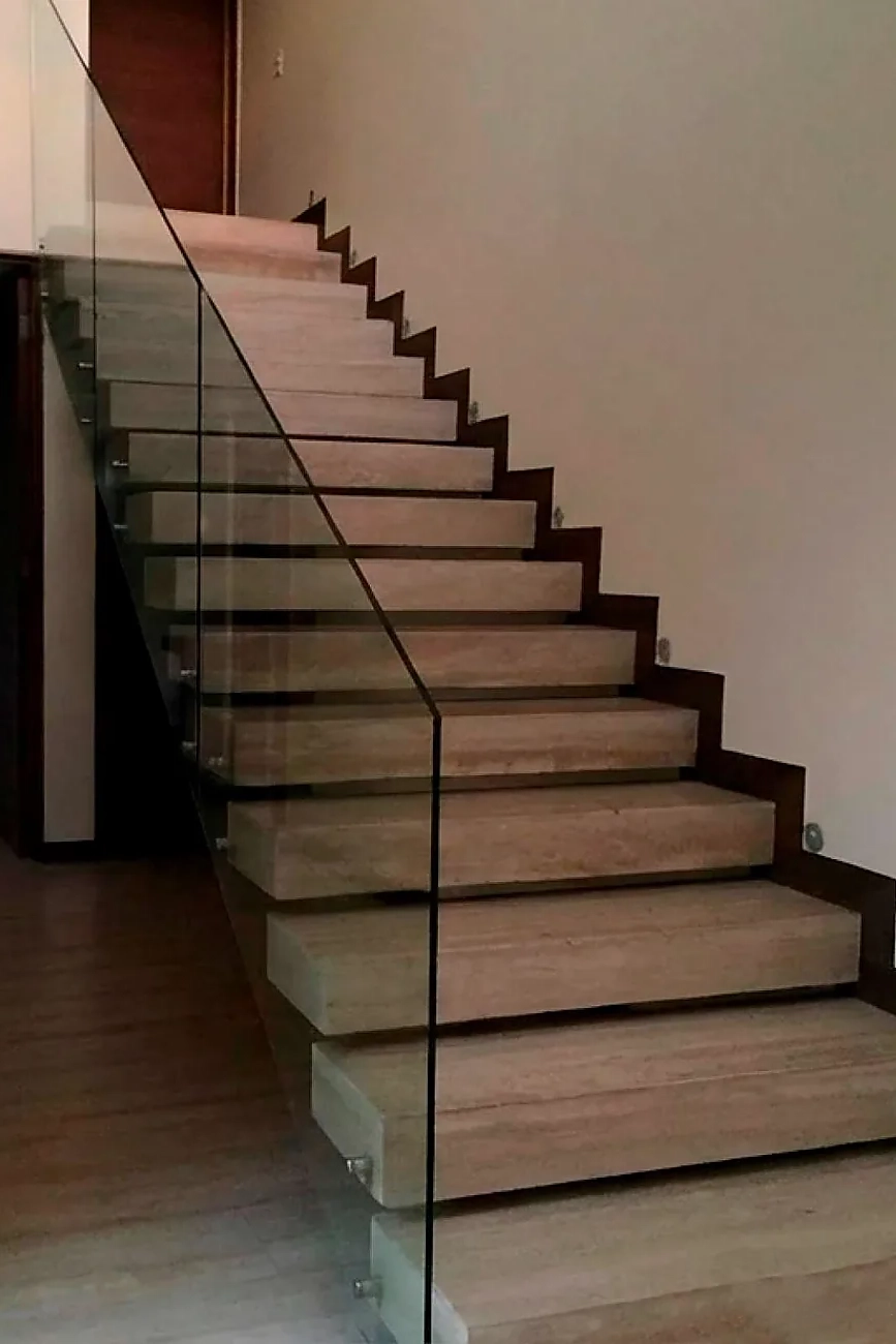 Interior arquitectónico con escalera y baranda de vidrio